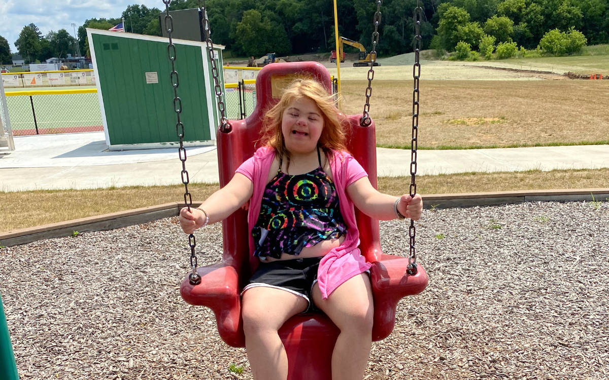 A child is swinging on the playground